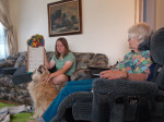 Carole and teen Bathany playing hangman in living room. Golden retriever Tahoe being petted.