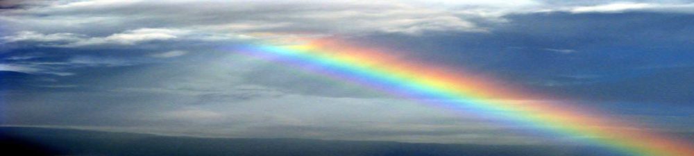 Storm clouds and rainbow over ocean.