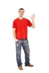 Young man in jeans with red shirt saying "Hi!"