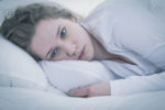 Tired woman lying in bed