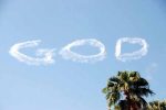 God is skywritten in a blue sky. Palm tree in corner.