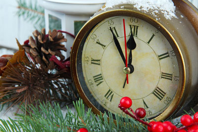Clock with hands set to 5 to Background of pine cones, pine branches, and red berries.