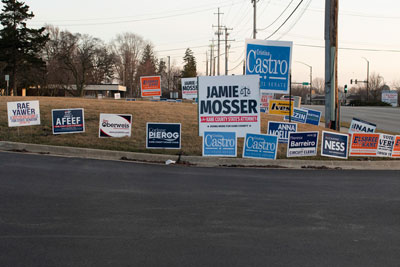 Multiple campaign signs along the street.